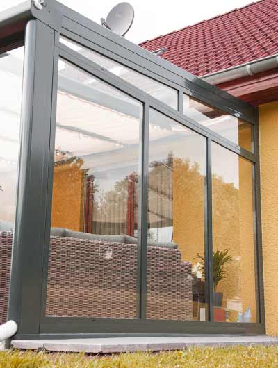 Seiten-Glas-Wand, Festelement Erkrath für Terrassenüberdachung, Anthrazit von der Seite mit Möbel, 10mm ESG und 8mm VSG Glas inkl. Sonnensegel
